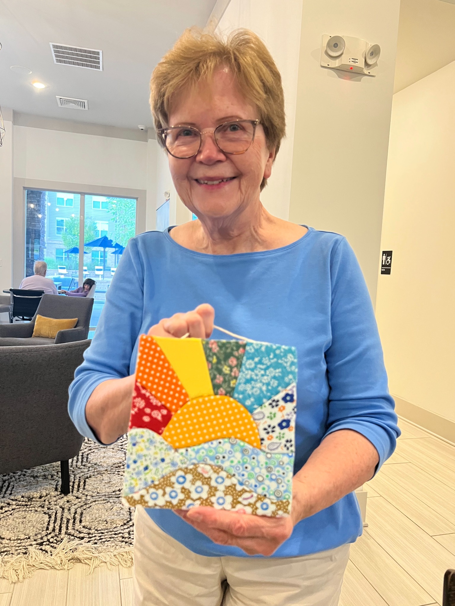 A participant holding up her finished kinusaiga fabric panel