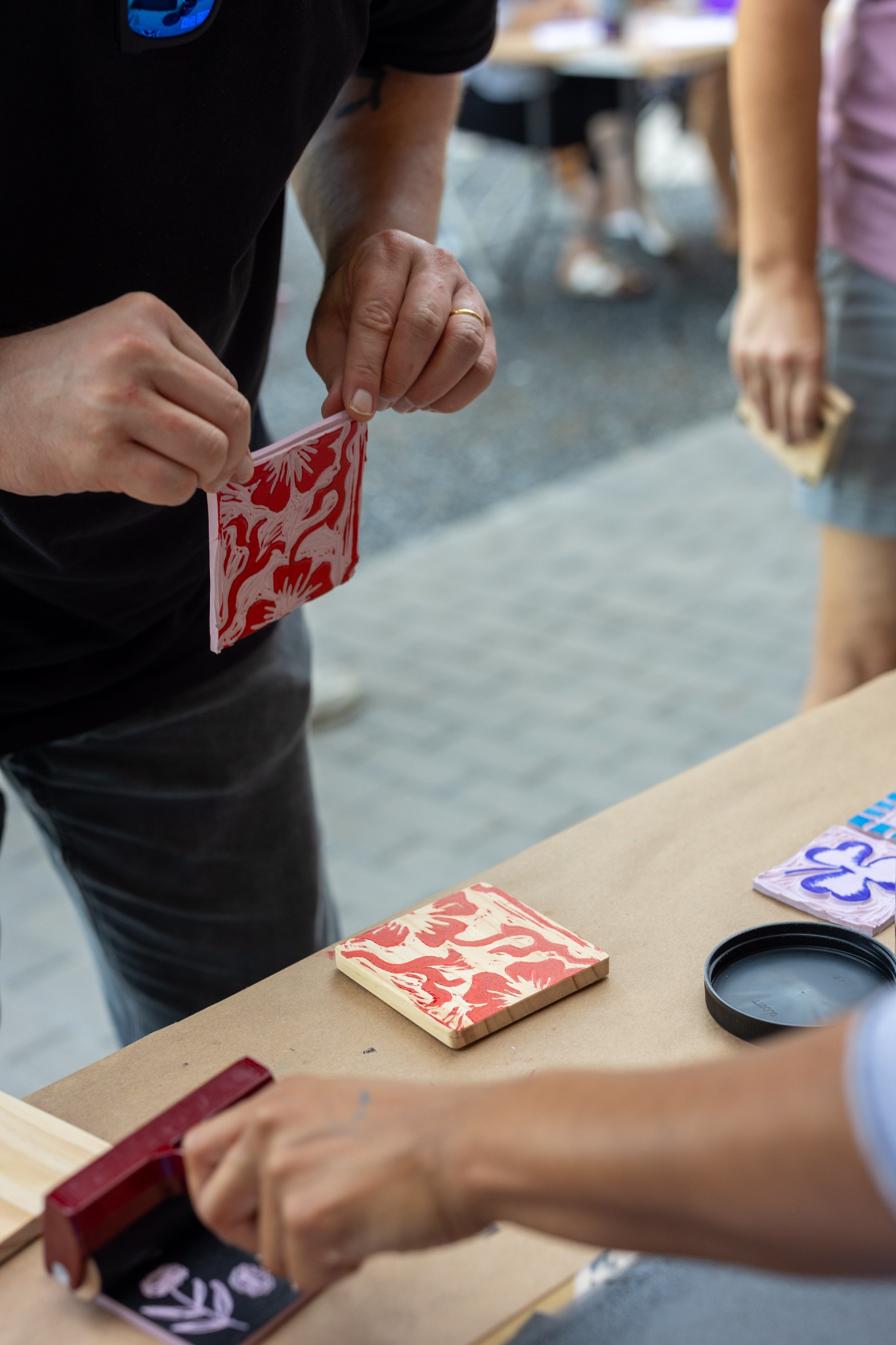 A red linocut block being inked during a printmaking workshop