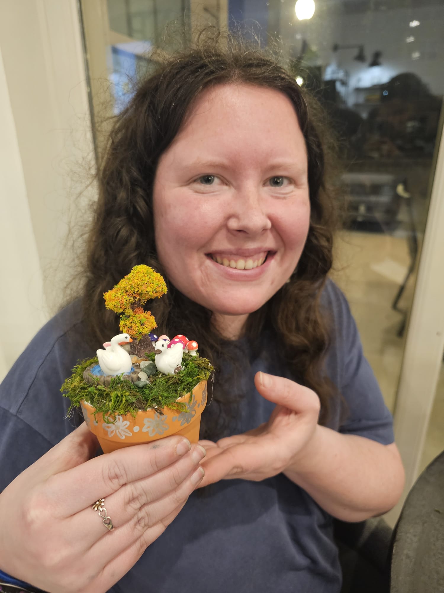 A participant tending a miniature teacup garden