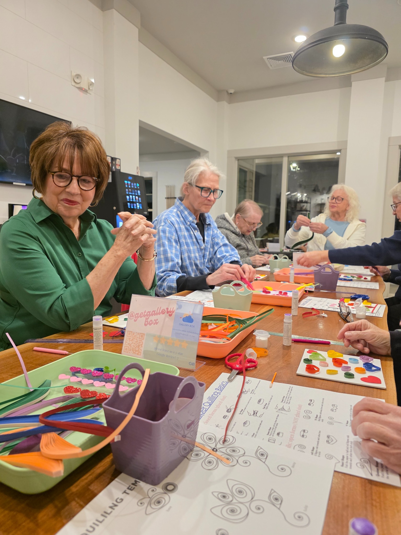 A full table of residents shaping paper quilling designs