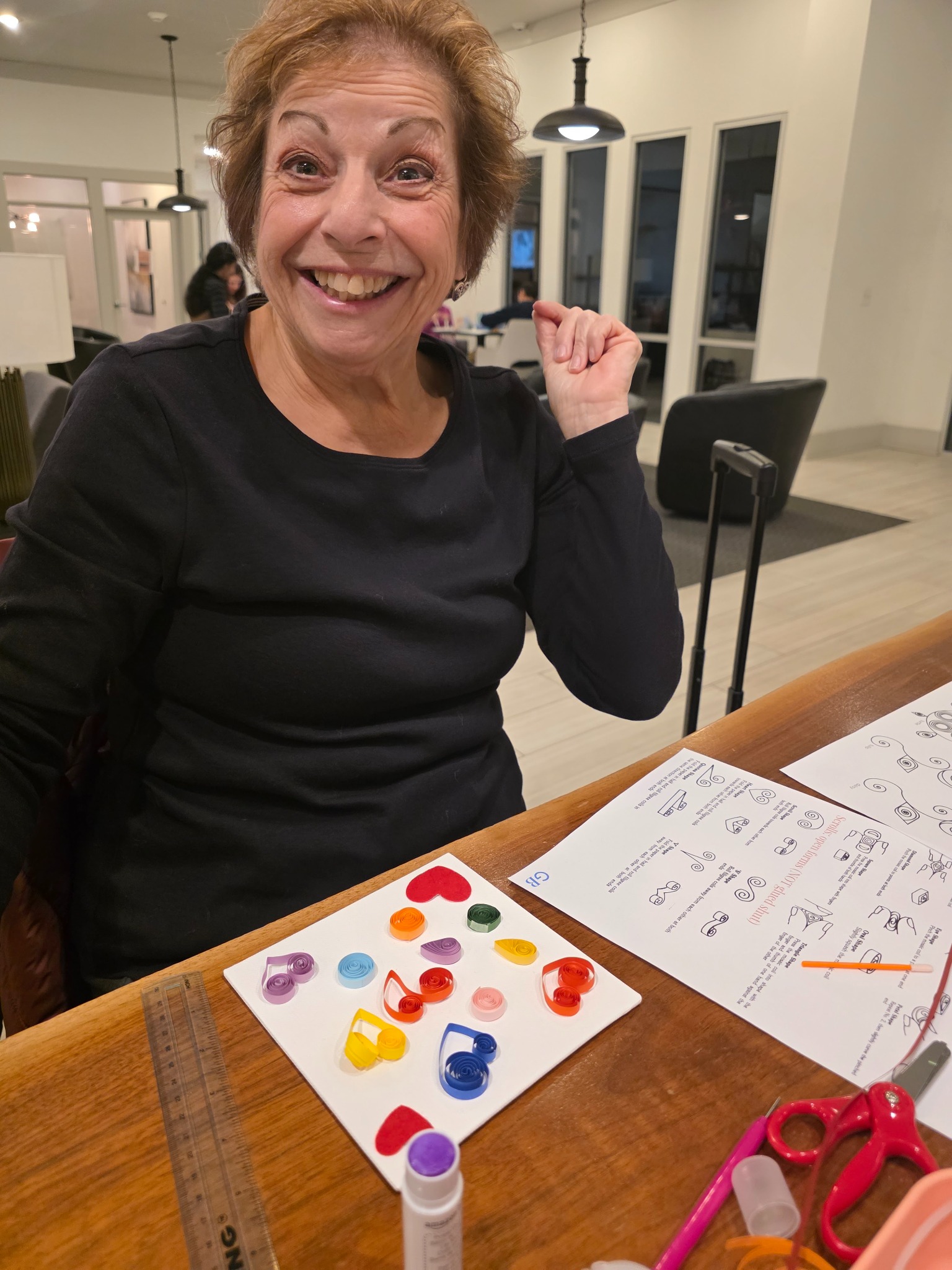 A happy participant holding up her quilled paper artwork