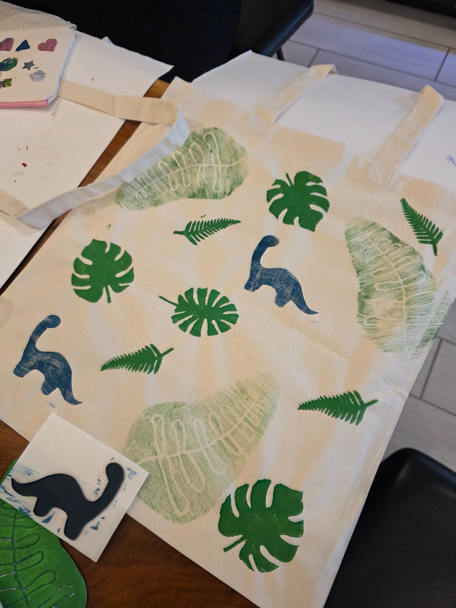 A finished canvas tote hand-printed with a dinosaur motif