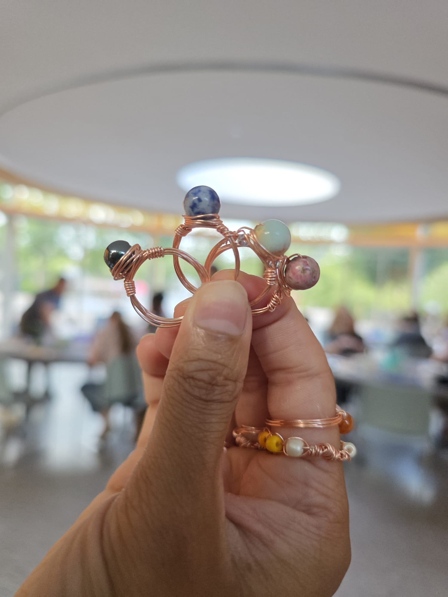 Close-up of handmade beaded wire rings with colored stones