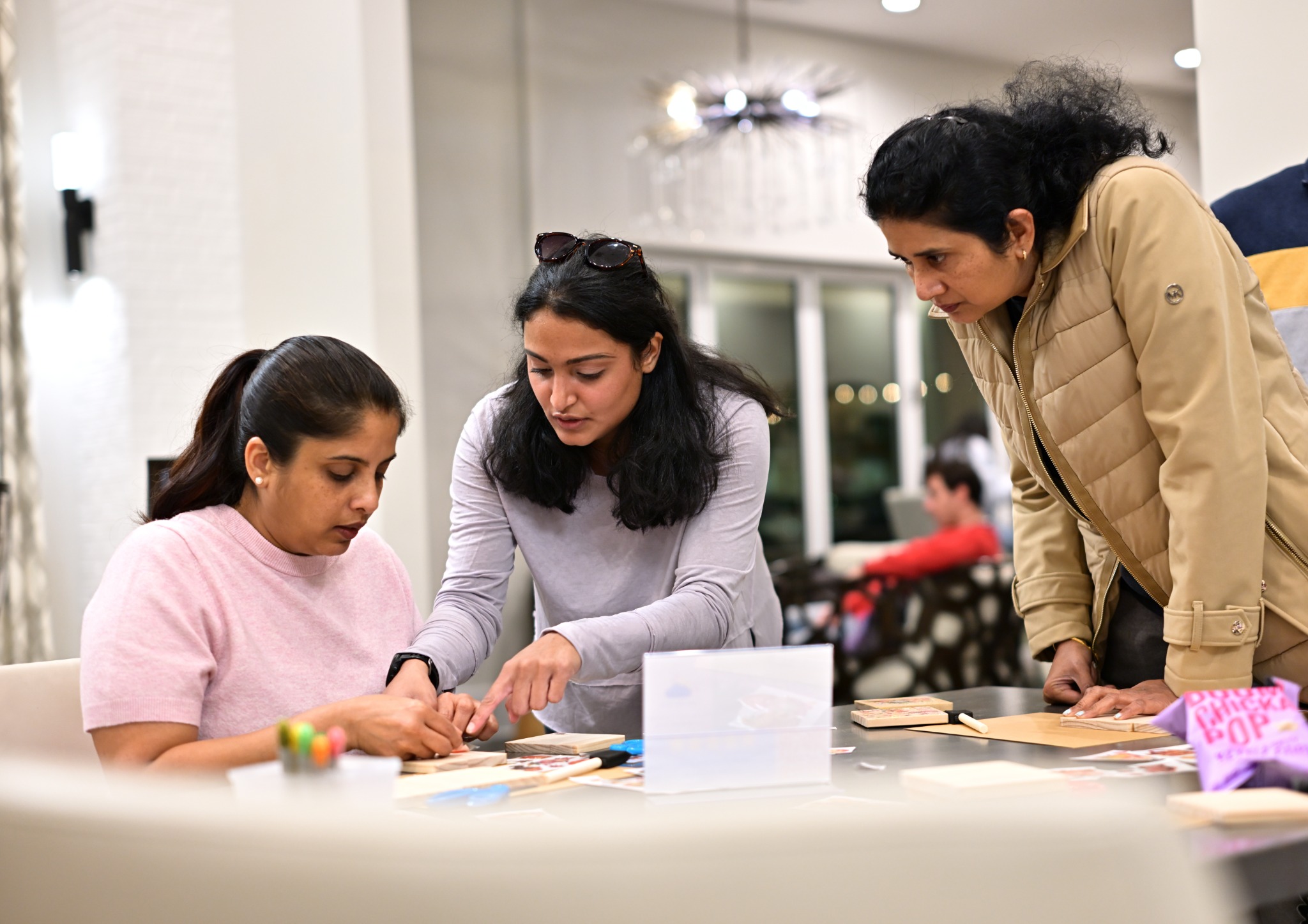 Three women laughing while making art together at a Gallery Box workshop